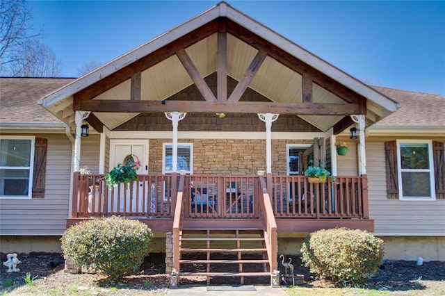 exterior space with covered porch and a shingled roof