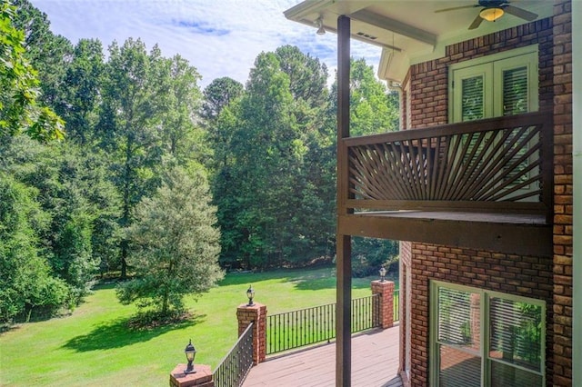 wooden terrace with a lawn and ceiling fan