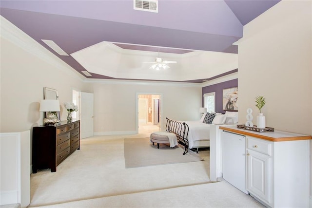 bedroom featuring a raised ceiling, crown molding, visible vents, and light carpet