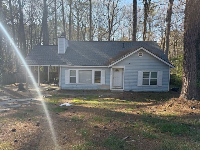 view of front of house featuring roof with shingles and a chimney