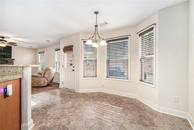 unfurnished dining area with ceiling fan with notable chandelier