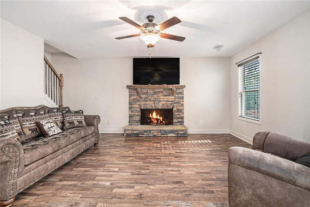 living room featuring ceiling fan, hardwood / wood-style floors, and a fireplace