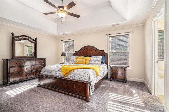 carpeted bedroom with a raised ceiling, ceiling fan, ornamental molding, and multiple windows