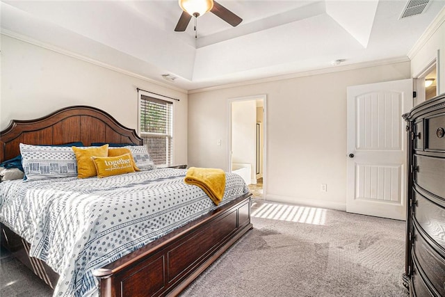 bedroom featuring crown molding, ensuite bath, ceiling fan, a raised ceiling, and light colored carpet