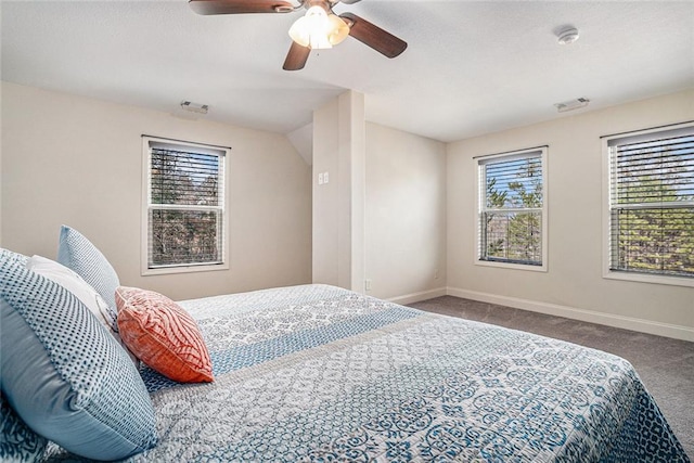 carpeted bedroom with ceiling fan and multiple windows