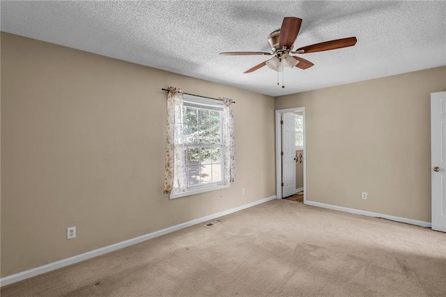 carpeted spare room featuring ceiling fan and a textured ceiling