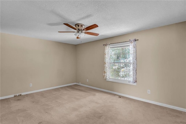 carpeted spare room featuring a textured ceiling and ceiling fan