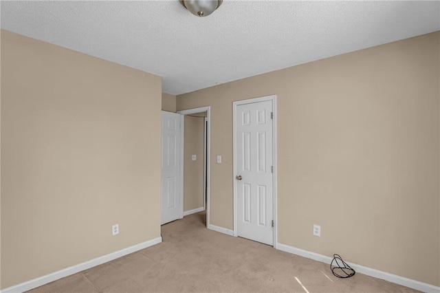 unfurnished bedroom with a textured ceiling and light colored carpet