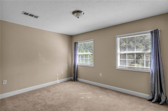 carpeted spare room with a textured ceiling