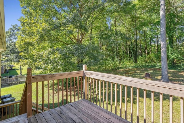 wooden deck featuring a lawn