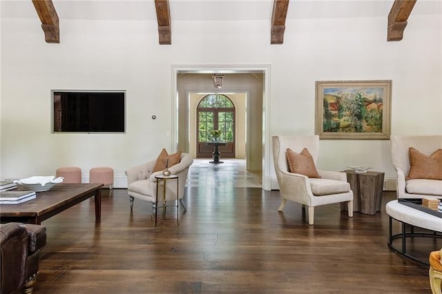 living area with beamed ceiling and wood finished floors