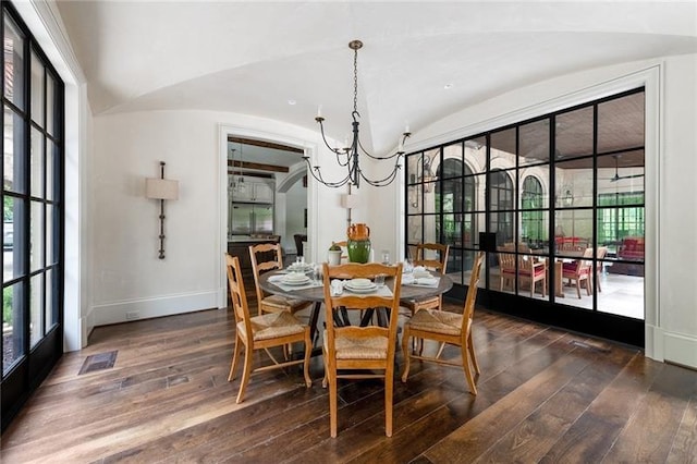 dining area featuring visible vents, baseboards, dark wood finished floors, a chandelier, and vaulted ceiling