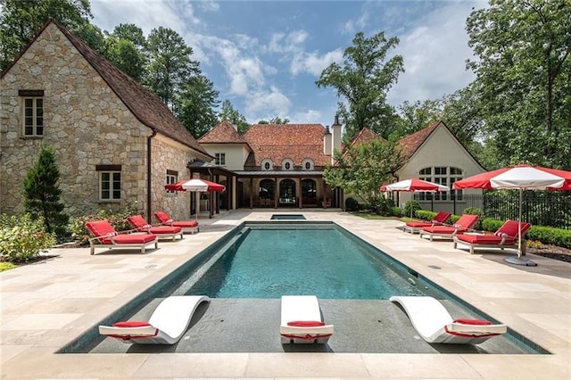 view of pool with a fenced in pool, fence, an in ground hot tub, and a patio area