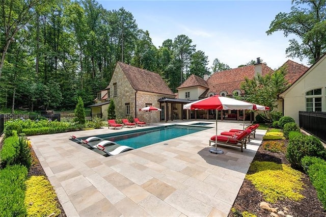 view of pool featuring a fenced in pool, an exterior structure, fence, an outdoor structure, and a patio