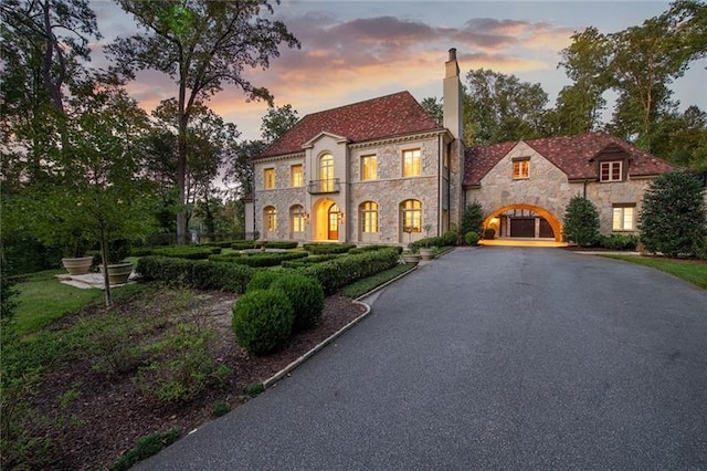 view of front of property featuring driveway and a chimney