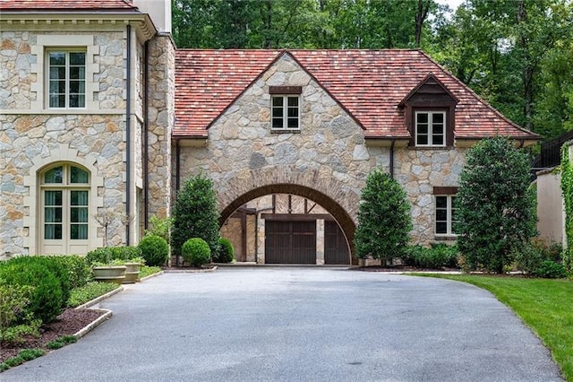 view of front facade with driveway, a chimney, and a garage