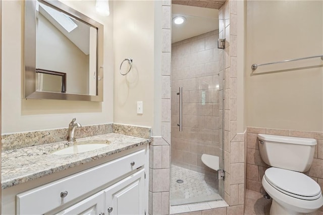 2011 Sturbridge Ln, Buford, GA 30519 - full bath featuring a stall shower, vanity, toilet, wainscoting, and tile walls