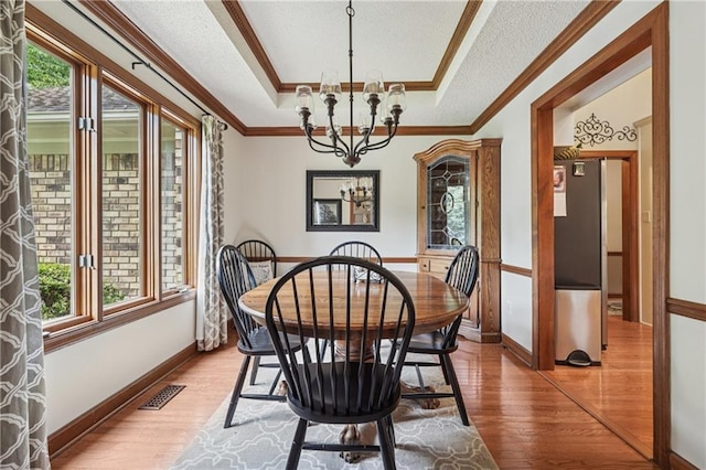 2011 Sturbridge Ln, Buford, GA 30519 - dining area featuring crown molding, wood finished floors, a raised ceiling, a chandelier, and baseboards