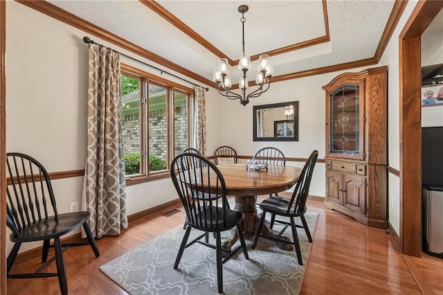 2011 Sturbridge Ln, Buford, GA 30519 - dining space featuring crown molding, a tray ceiling, healthy amount of natural light, a chandelier, and wood finished floors