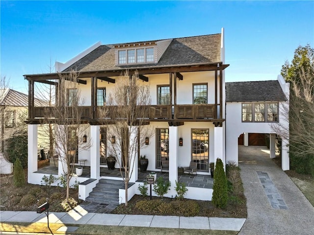 view of front facade with a carport and a balcony