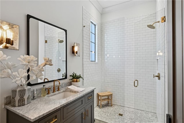 bathroom with vanity, a shower with shower door, and ornamental molding