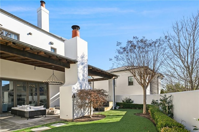 back of property with a lawn, outdoor lounge area, and a patio