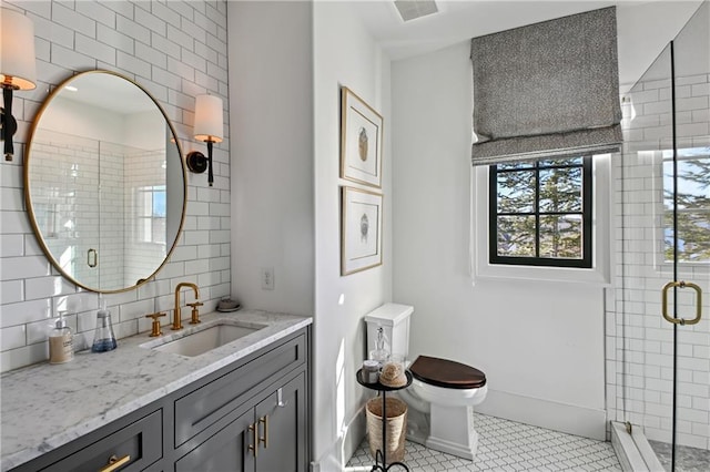 bathroom featuring vanity, tile patterned flooring, decorative backsplash, toilet, and walk in shower