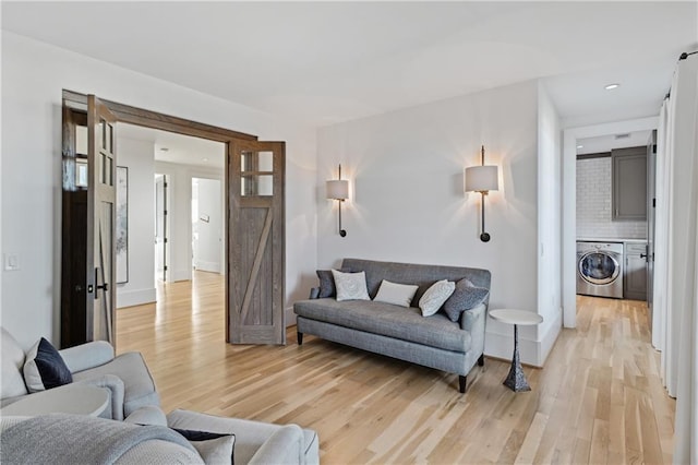 living room featuring light hardwood / wood-style floors and independent washer and dryer