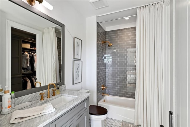 full bathroom with tile patterned floors, shower / bath combo with shower curtain, vanity, and toilet