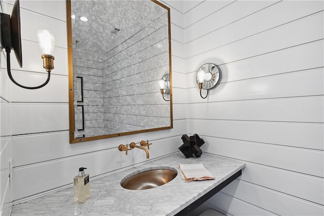 bathroom with wood walls and vanity