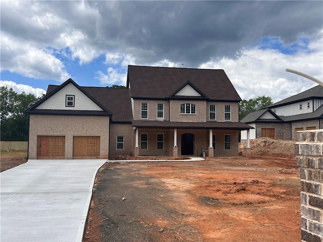 view of front of home with concrete driveway, covered porch, and a garage