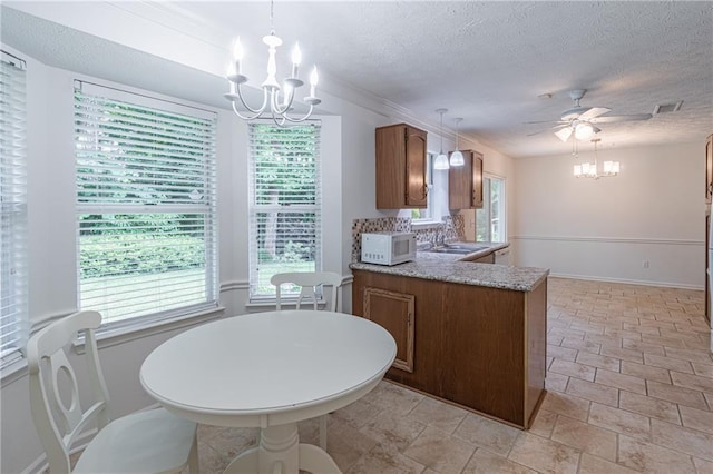 4307 Windward Ln, Norcross, GA 30093 - kitchen featuring white microwave, a chandelier, brown cabinets, and a textured ceiling