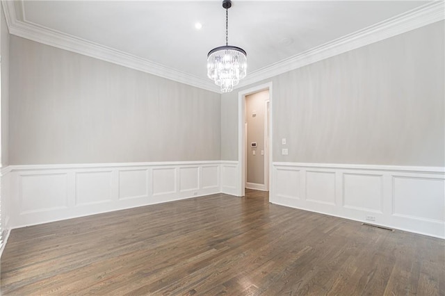 empty room featuring an inviting chandelier, ornamental molding, and dark hardwood / wood-style floors