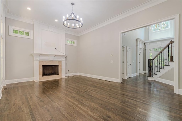 unfurnished living room featuring an inviting chandelier, crown molding, a high end fireplace, and dark hardwood / wood-style floors