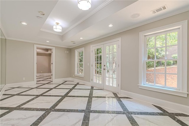 empty room featuring french doors, crown molding, plenty of natural light, and a tray ceiling