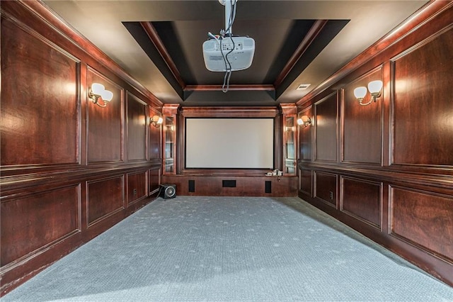 carpeted cinema with crown molding and a raised ceiling