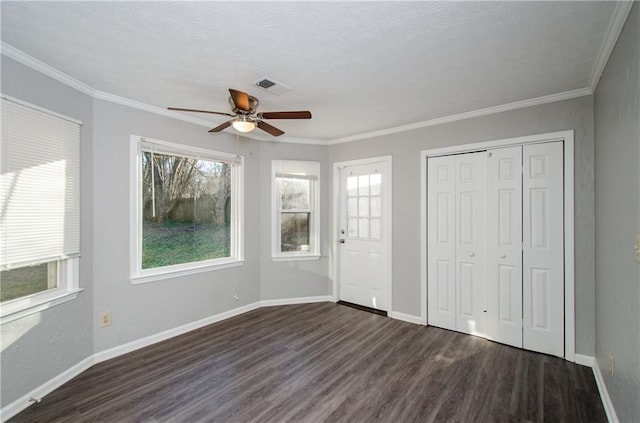 unfurnished bedroom with ornamental molding, ceiling fan, dark hardwood / wood-style flooring, and multiple windows