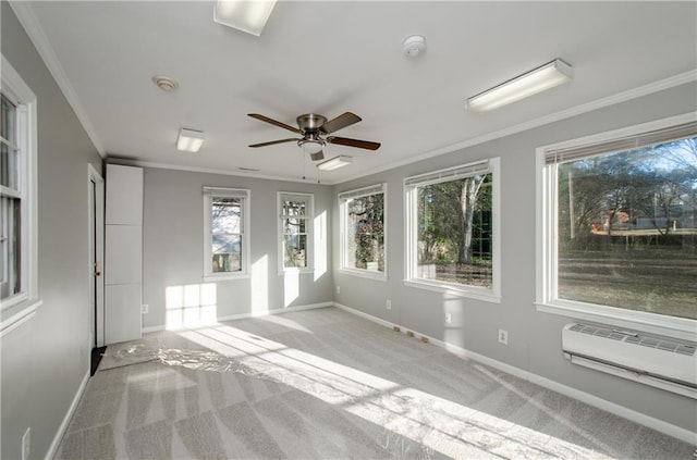 empty room featuring an AC wall unit, ceiling fan, crown molding, and light carpet