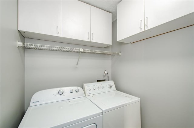 clothes washing area with cabinets and independent washer and dryer