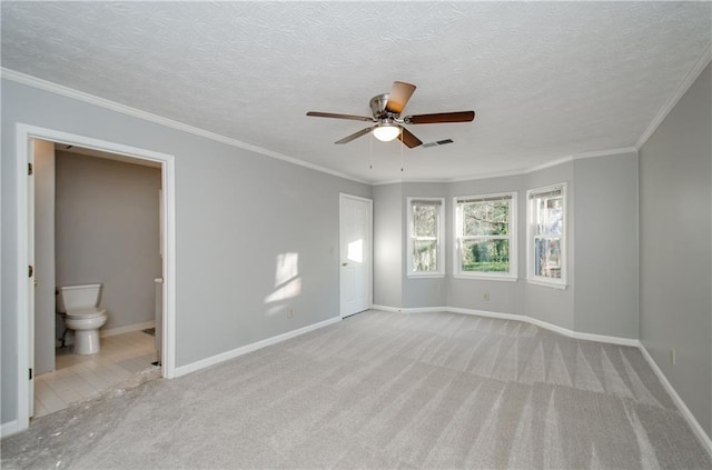 unfurnished bedroom featuring ensuite bathroom, light colored carpet, ceiling fan, and ornamental molding