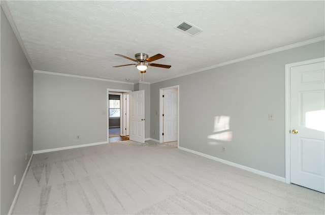 unfurnished room featuring a textured ceiling, ceiling fan, crown molding, and light colored carpet