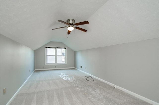 additional living space with ceiling fan, vaulted ceiling, and light carpet