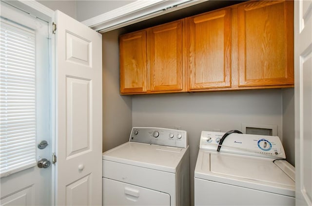 laundry area with washing machine and dryer and cabinets