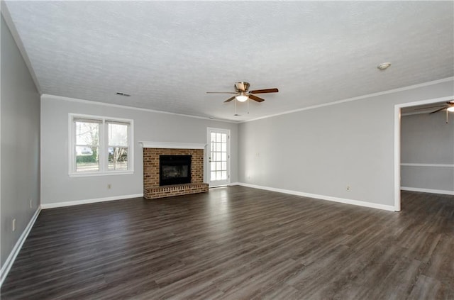 unfurnished living room with plenty of natural light, a fireplace, ornamental molding, and dark hardwood / wood-style floors