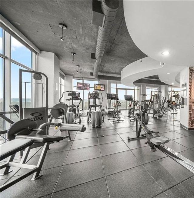 gym featuring expansive windows and a healthy amount of sunlight