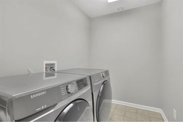 laundry area featuring laundry area, washing machine and dryer, baseboards, and light floors