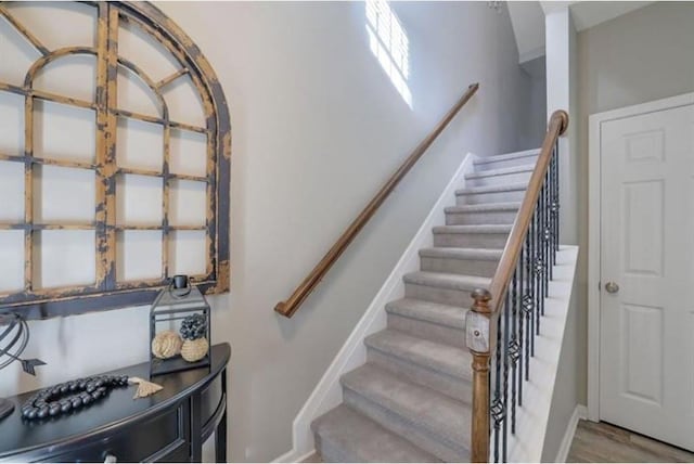 staircase with baseboards and wood finished floors