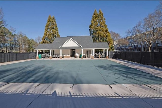 community pool with a patio and fence