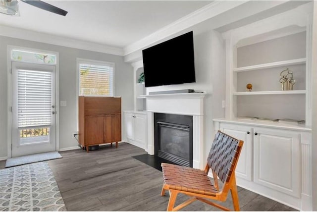 living area with plenty of natural light, dark wood finished floors, and crown molding