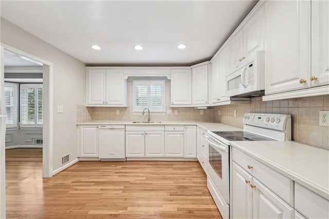 2655 Nesbit Trl, Alpharetta, GA 30022 - kitchen featuring white appliances, light wood finished floors, white cabinets, light countertops, and decorative backsplash
